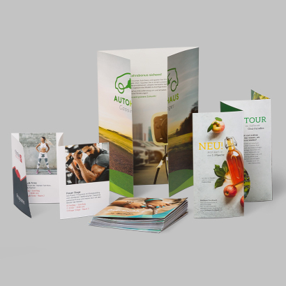 Folder mit Cellophanierung auf grauem Hintergrund