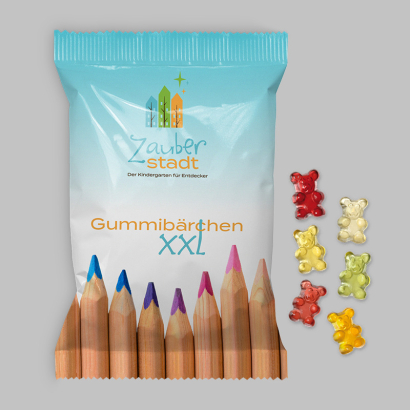 Individuell gestaltete XXL-Verpackung daneben Fruchtgummis liegend vor grauem Hintergrund