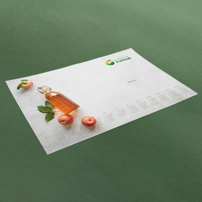 Individuell gestaltete Schreibtischunterlagen vor grünem Hintergrund