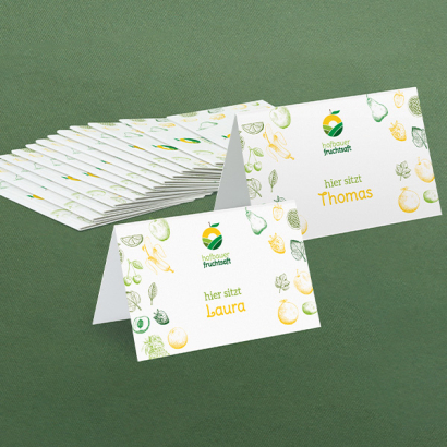 Individuell gestaltete Tischkarten vor grünem Hintergrund