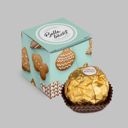 Mini-Kartonwürfel individuell bedruckt und daneben Ferrero Rocher auf grauem Hintergrund