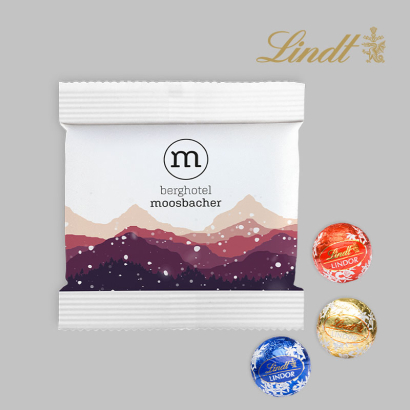 Lindor 3er Papiertütchen liegend neben bedrucktem Säckchen