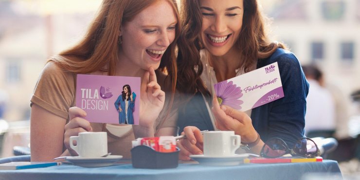 zwei Frauen halten eine bedruckte Postkarte