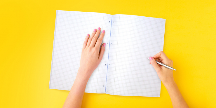 Frau schreibt in bedruckten Collegeblock