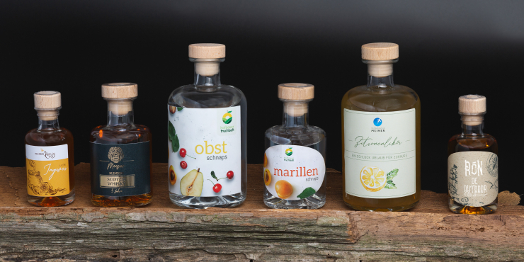 unterschiedliche Spirituosen nebeneinander auf einem Holz