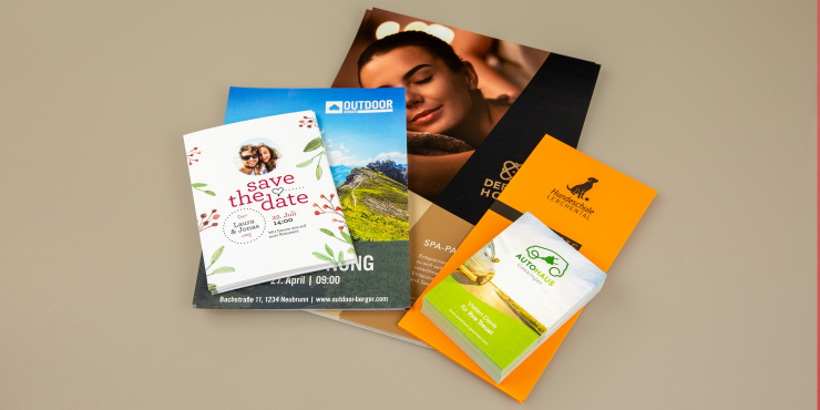 individuell bedruckte Flyer in unterschiedlichen Formaten auf braunem Hintergrund