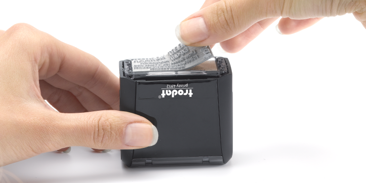 Jemand tauscht Textplatten beim Stempel aus