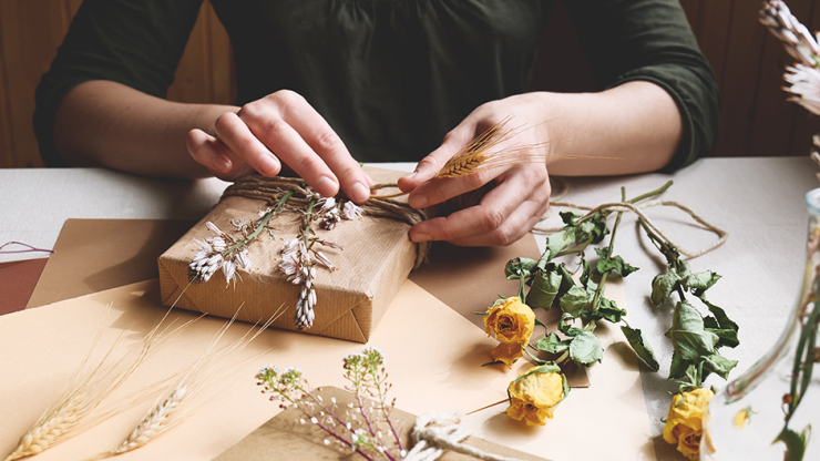 Frau bindet nachhaltige Geschenke ein