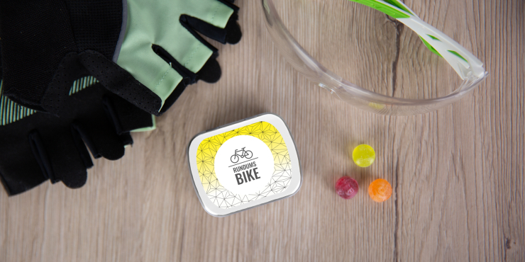 Individuell bedruckte Klappdose mit Pulmoll liegend zwischen Fahrradhandschuhe und Lanyards