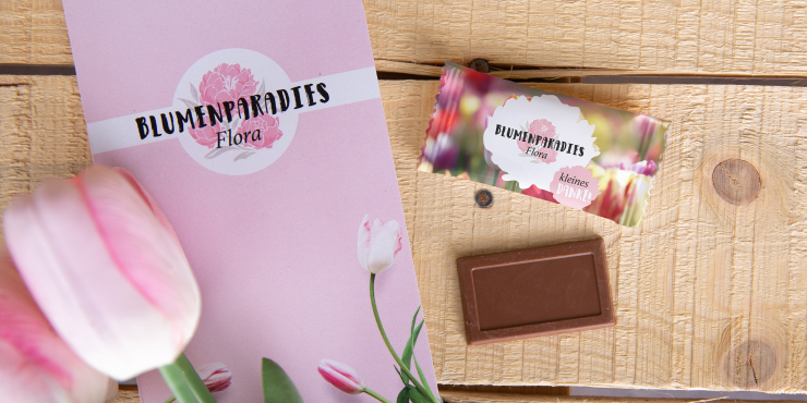 Individuell gestaltete Schokoladentafel neben Broschüre auf Tisch