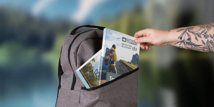 Jemand holt ein Bestpreis-Buch aus einem grauen Rucksack hervor