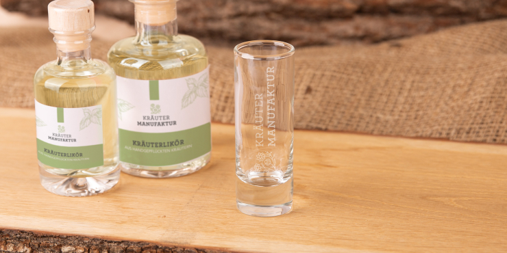 Schnapsglas mit Schnapsflaschen auf Holz