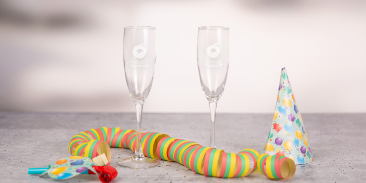 Zwei Sektgläser auf einem Tisch mit Partygirlande