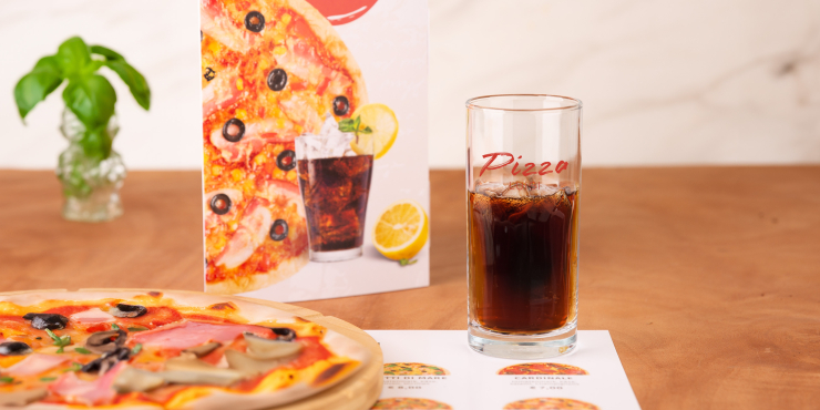 Trinkglas auf einem Tisch mit Pizza