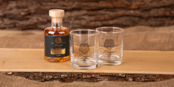 Zwei Whiskeygläser und eine Flasche auf einem Holz