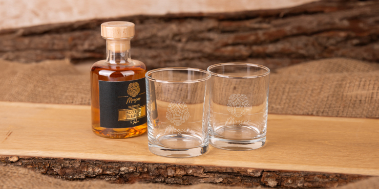 Zwei Whiskeygläser und eine Flasche auf einem Holz