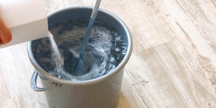 Kübel mit Wasser, in dem Tapetenkleister eingerührt wird