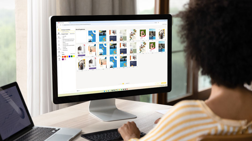 Eine Person sitzt vor einem Bildschirm und schaut sich unsere Kalendervorlagen im Online-Designer an