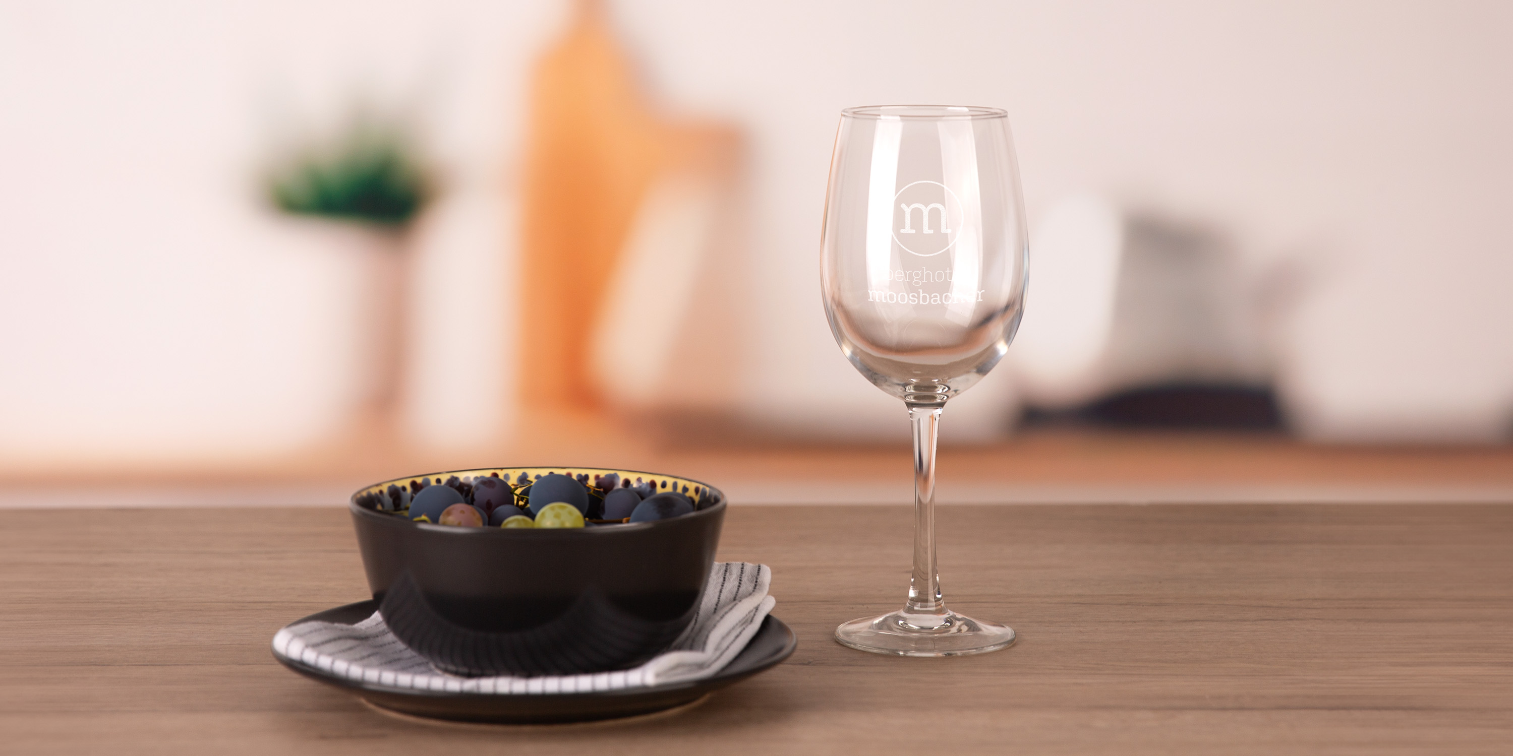 Ein Weinglas neben einem Suppenteller auf einem Holztisch