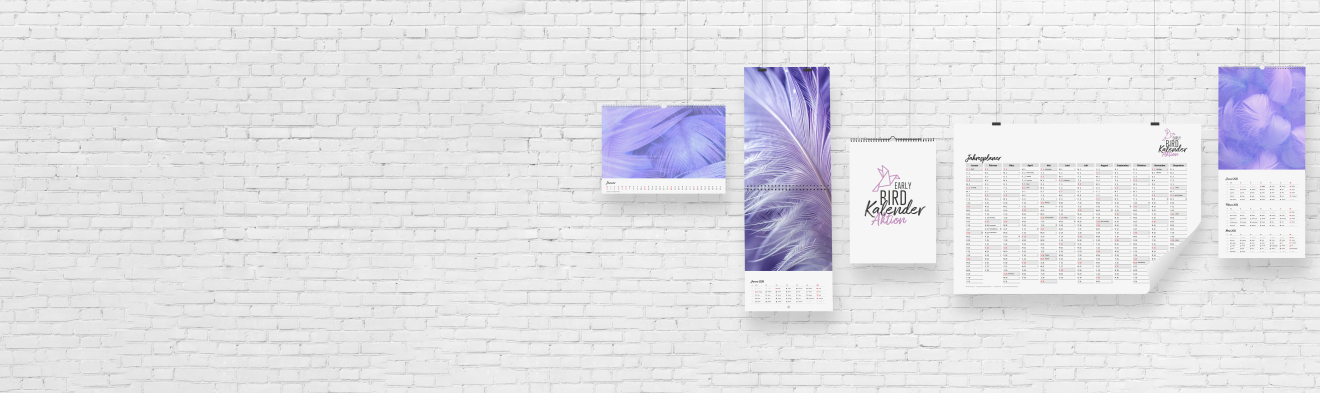 Verschiedene bedruckte Kalender hängen auf einer weißen Wand und zeigen die Early Bird Aktion