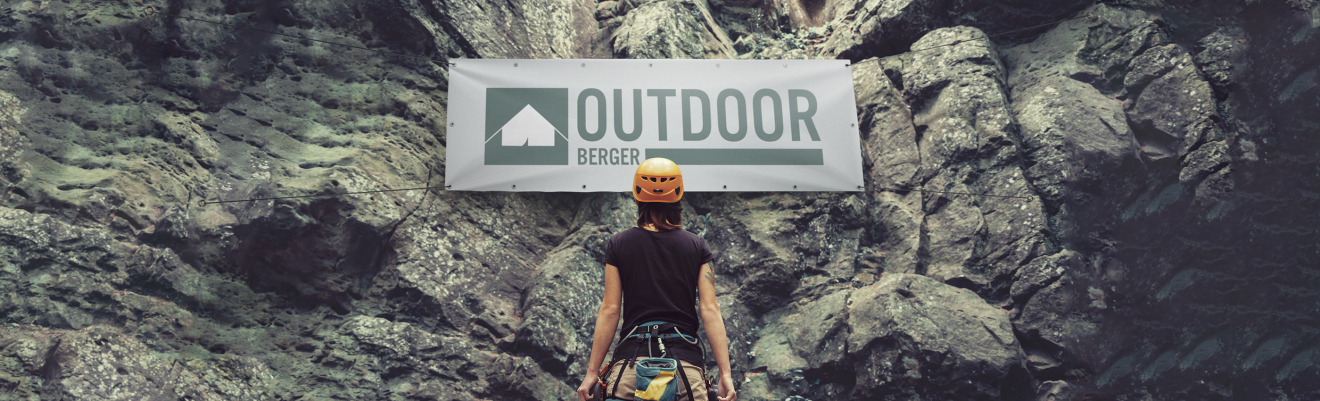 Person steht vor einem Banner für den Outdoorbereich