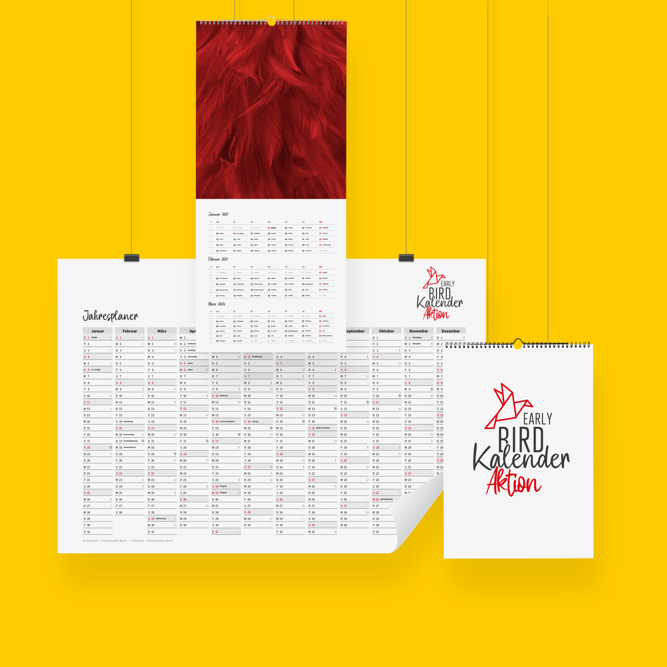 Verschiedene bedruckte Kalender hängen auf einer weißen Wand und zeigen die Early Bird Aktion