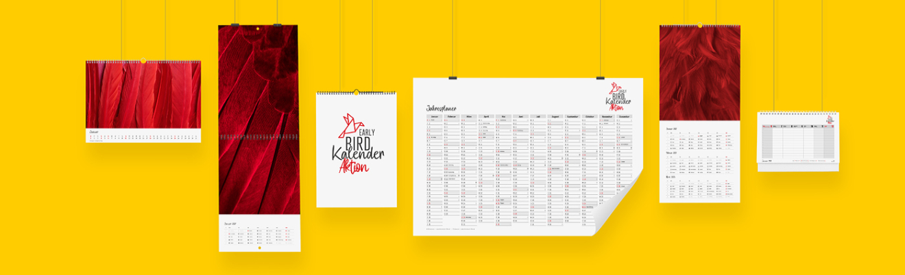 Verschiedene bedruckte Kalender hängen auf einer gelben Wand und zeigen die Early Bird Aktion