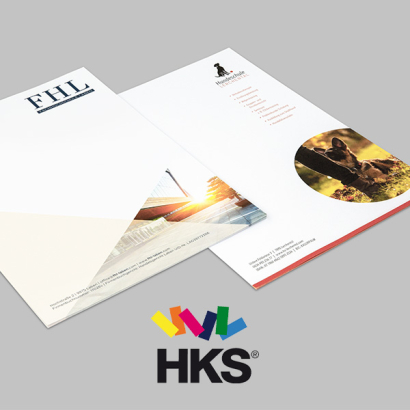 Briefpapier mit HKS auf grauem Hintergrund