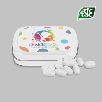 Individuell gestaltete Mini-Klappdose, davor einige Tic Tacs liegend vor grauem Hintergrund