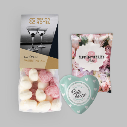 Verschiedene individuell bedruckte Valentinstags-Produkte vor grauem Hintergrund