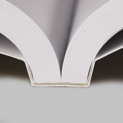 Softcover Klebebindung auf grauer Unterlage