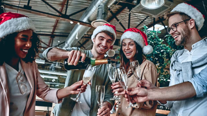 Personen, die auf einer Weihnachtsfeier, mit Sekt anstoßen