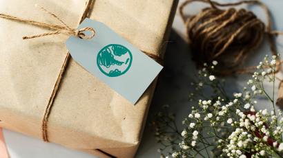 Ein geschnürter nachhaltiger Karton mit einer Marke auf der eine gezeichnete Erdkugel zu sehen ist.