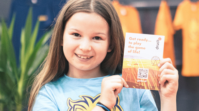 Ein Mädchen hält eine Broschüre in der Hand