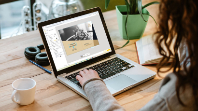 Eine Person sitzt vor einem Laptop und benutzt den Online-Designer