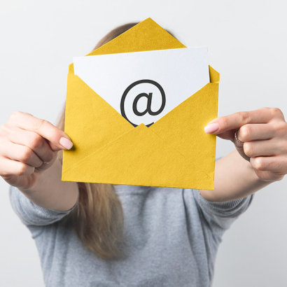 Eine Person hält einen gelben Briefumschlag in der Hand