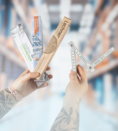 Person hält verschiedene personalisierte Zollstöcke in den Händen