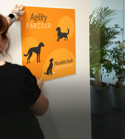 Person bringt individuelle PET-Hartschaumplatte an Wand an