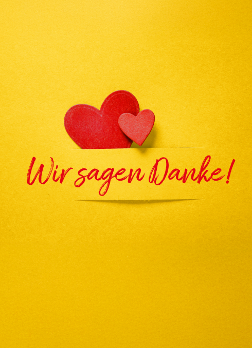 Gelber Hintergrund mit großen roten Herz und kleinen dunkelrosigen Herz mit der roten Aufschrift "Wir sagen Danke!"