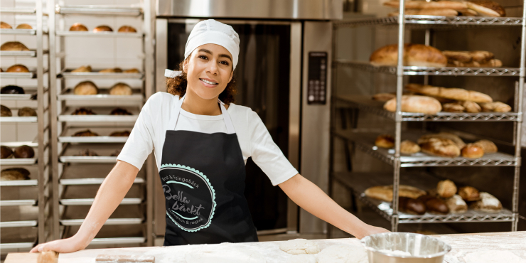 Frau mit schwarz individuell bedruckter Kochschürze in Bäckerei