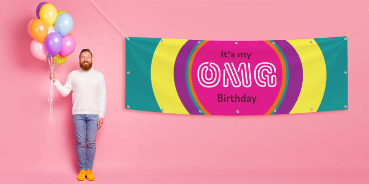 Eine Person mit Luftballons steht neben einem bunten Partybanner