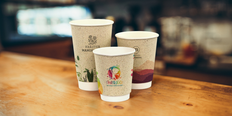 verschiedene bedruckte Becher auf Holz