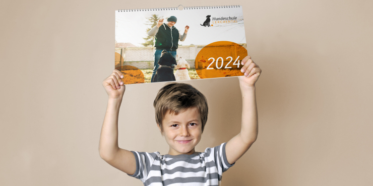 Junge hält einen bedruckten Wandkalender