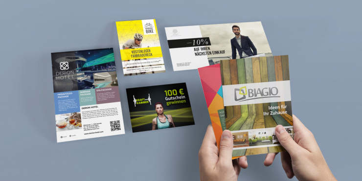 individuell bedruckte Flyer in unterschiedlichen Formaten auf grauem Hintergrund