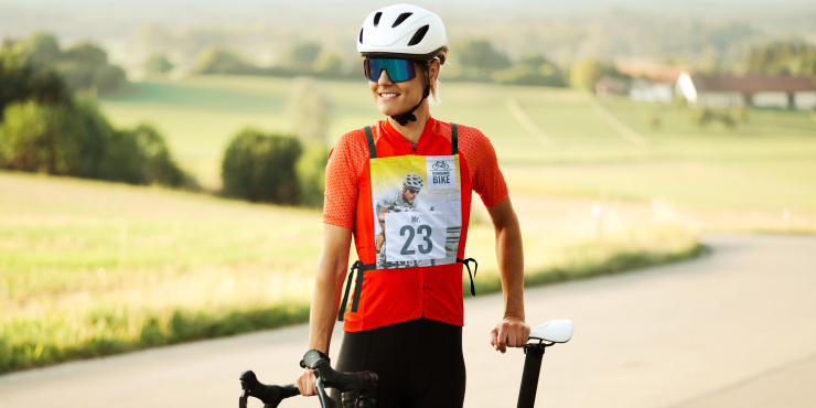 Individuelle Startnummer an Radfahrerin neben Fahrrad