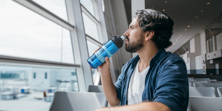 Mann der aus individuell bedruckte Trinkflasche trinkt