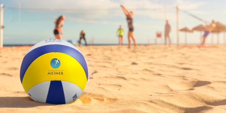 Individuell bedruckter Volleyball liegend am Strand