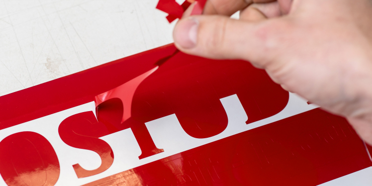Die überschüssige rote Folie der einzelnen Buchstaben wird abgezogen 
