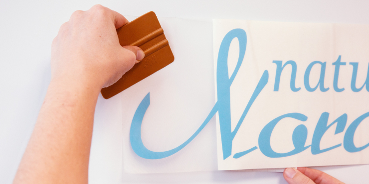 Das blaue Motiv wird auf eine weiße Wand geklebt
