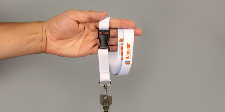 Jemand hält ein Lanyard mit einem Haken und Schnappverschluss